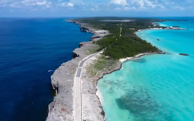 The coast road along the narrow ridge of Eleuthera, The Bahamas, with dark Atlantic water on one side and turquoise shallows on the other
