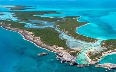 Aerial view of a cay in the Exumas, The Bahamas, ringed by shallow turquoise water