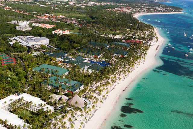 Beachfront all-inclusive resort with palms lining the turquoise shore at Punta Cana / Bávaro, Dominican Republic