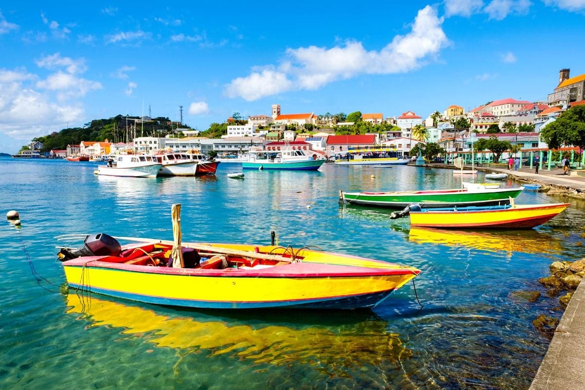 Colourful fishing boats moored in the Carenage harbour below the red rooftops of St. George's, Grenada