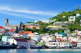 Red-roofed Georgian buildings rising around the horseshoe Carenage harbour of St. George's, Grenada