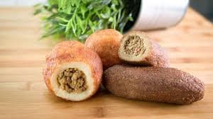 Alcapurrias, fried fritters cut open to show the seasoned meat filling