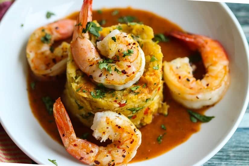 Mofongo topped with seasoned shrimp in a savory sauce