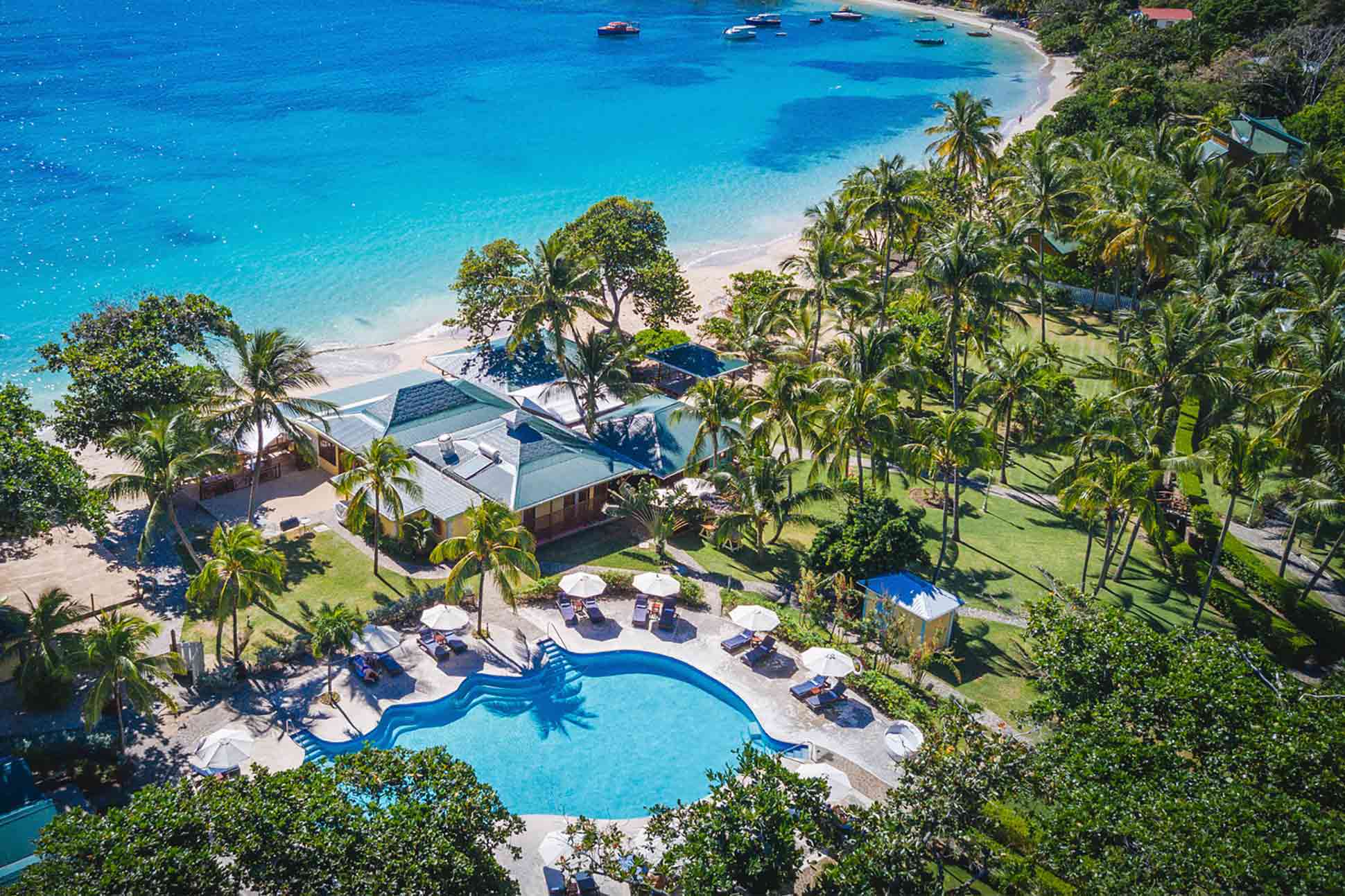 Bequia Beach Hotel aerial view with pool, palm trees and turquoise bay
