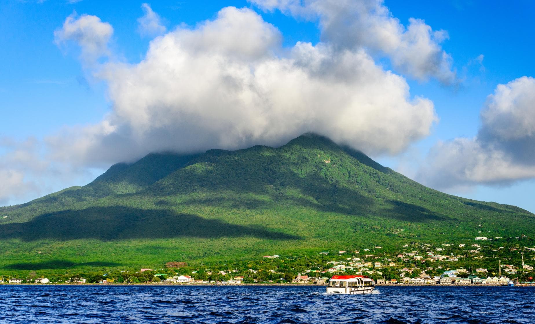 Pinney's Beach and palm trees on Nevis with St. Kitts beyond