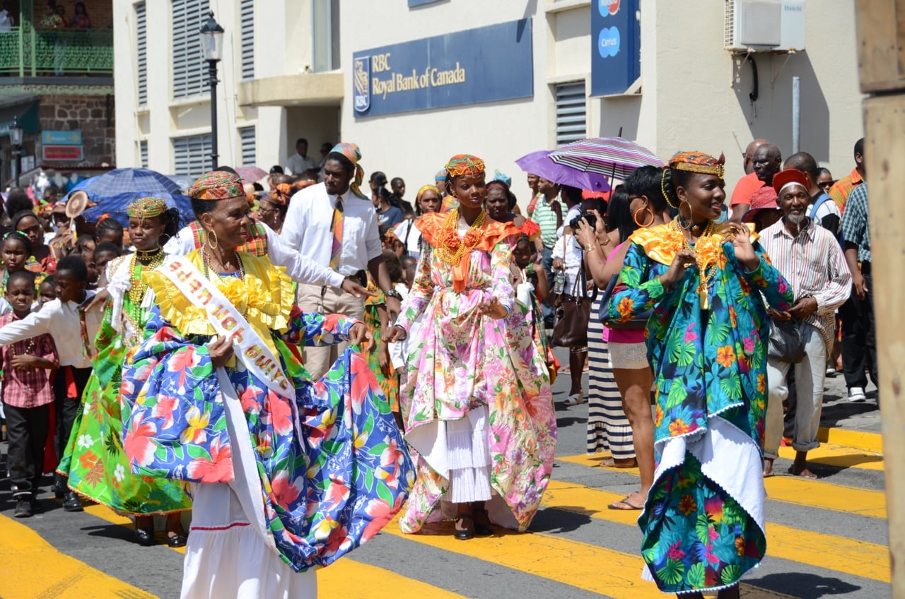 Dominica Independence Day parade — performers in traditional dress marching through Roseau