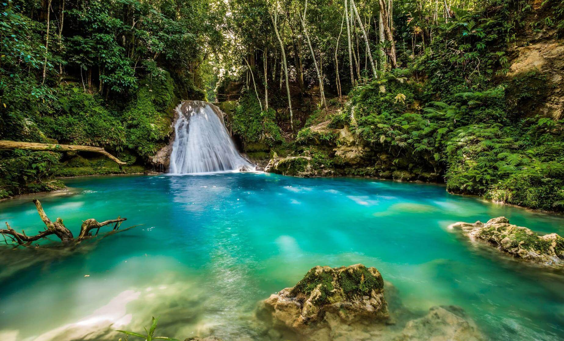 Turquoise waterfall and blue hole in the lush Jamaican countryside