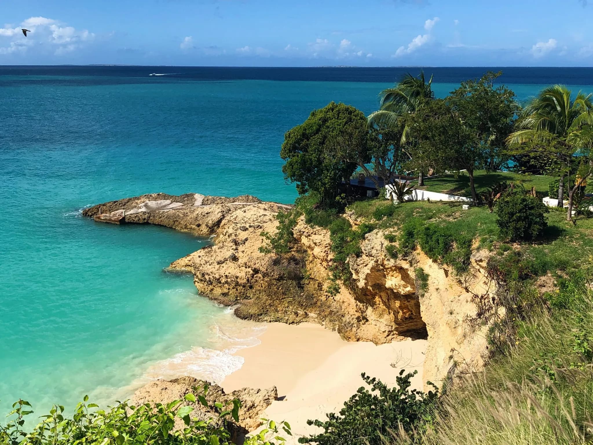 Turquoise water and a small sand cove below a low cliff on the Anguilla coast