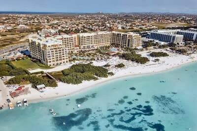 Palapa-shaded pools and beachfront resorts at Palm Beach, Aruba