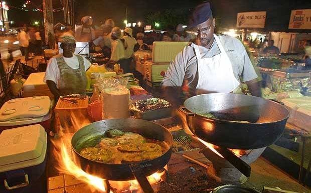 Vendors grilling fresh fish over open flames at the lively Oistins Fish Fry night market in Barbados