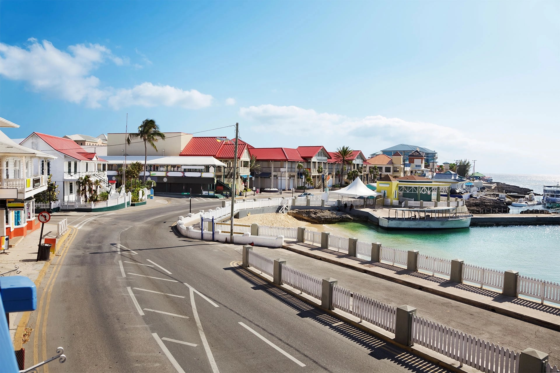 The red-roofed George Town waterfront on Grand Cayman beside turquoise water, the arrival point for Cayman Islands transfers