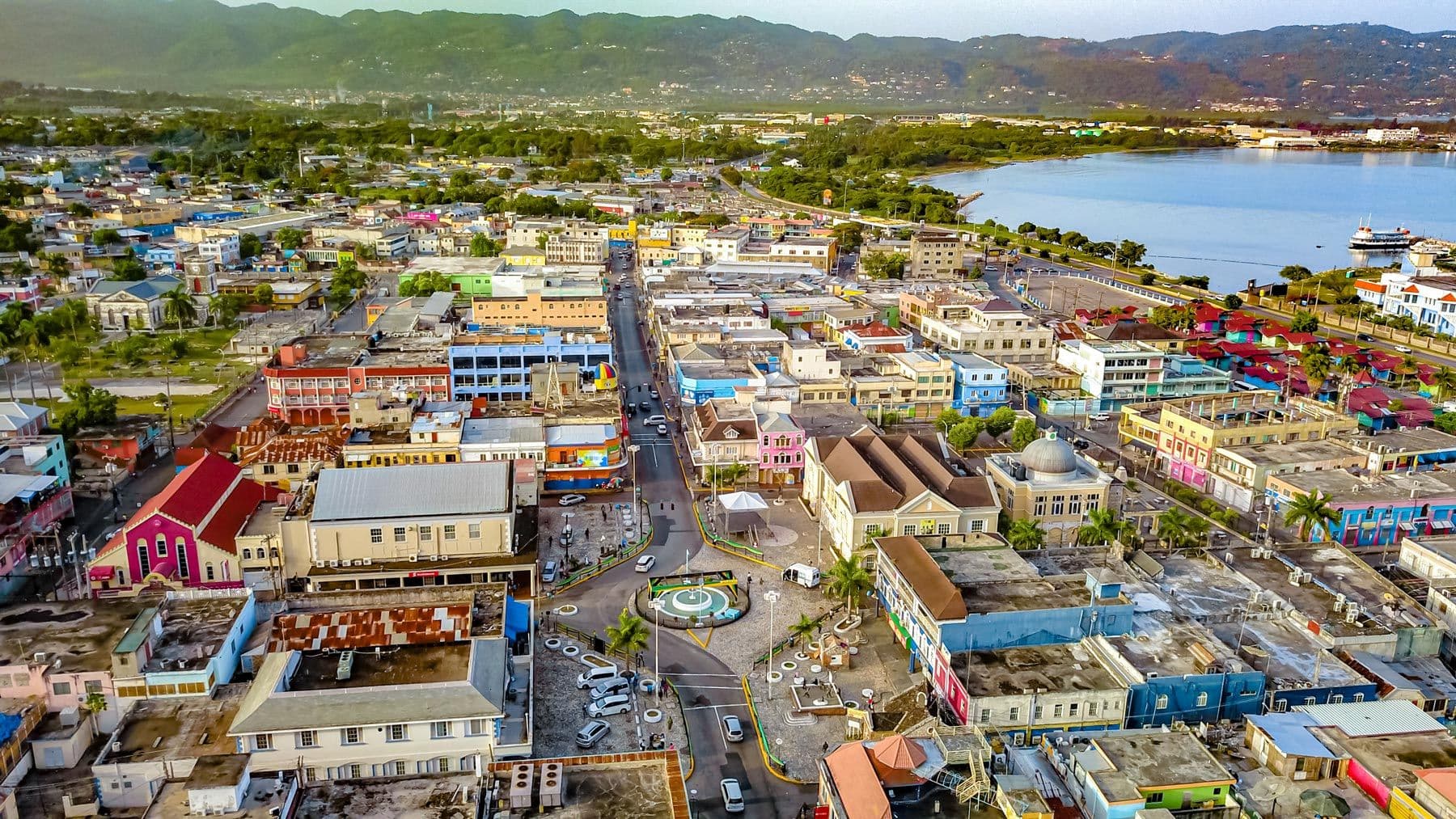 Aerial view of downtown Montego Bay with colourful buildings, the harbour and green hills behind, Jamaica