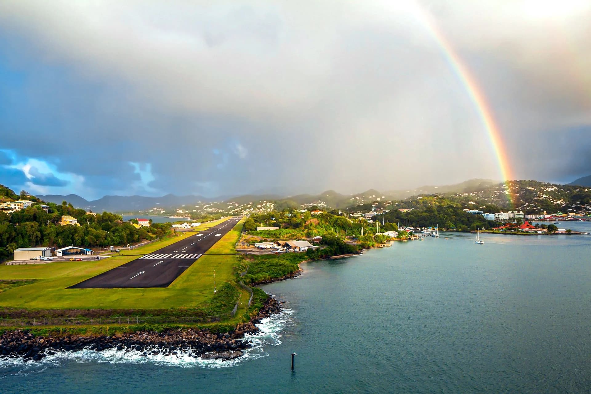 Aerial view of George F. L. Charles Airport's seaside runway in Castries with a rainbow overhead, Saint Lucia