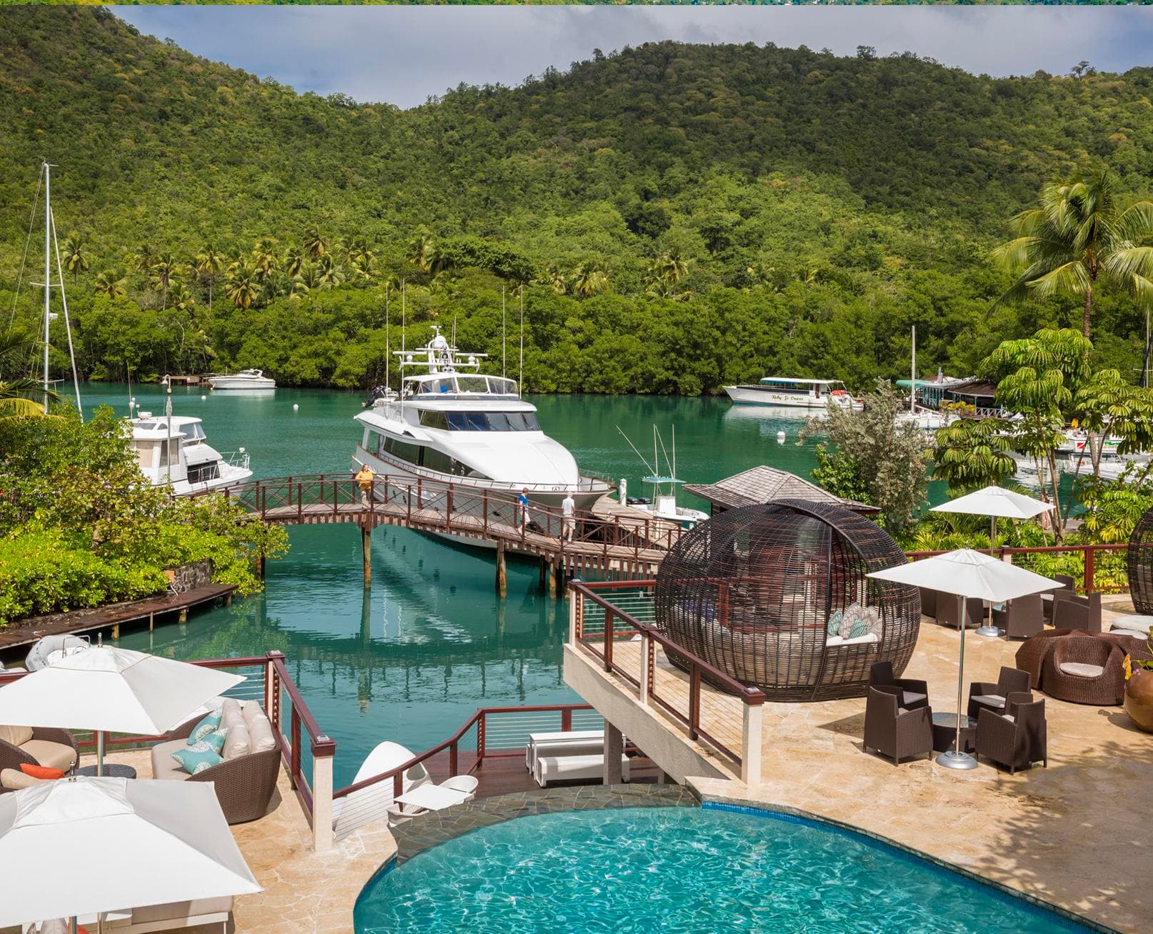 Yachts and a superyacht moored in the sheltered, mangrove-fringed harbour of Marigot Bay, Saint Lucia