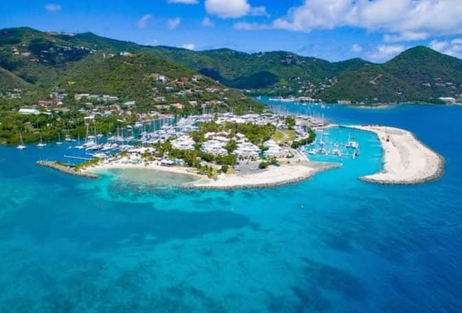 A charter yacht anchored in a calm blue bay in the British Virgin Islands