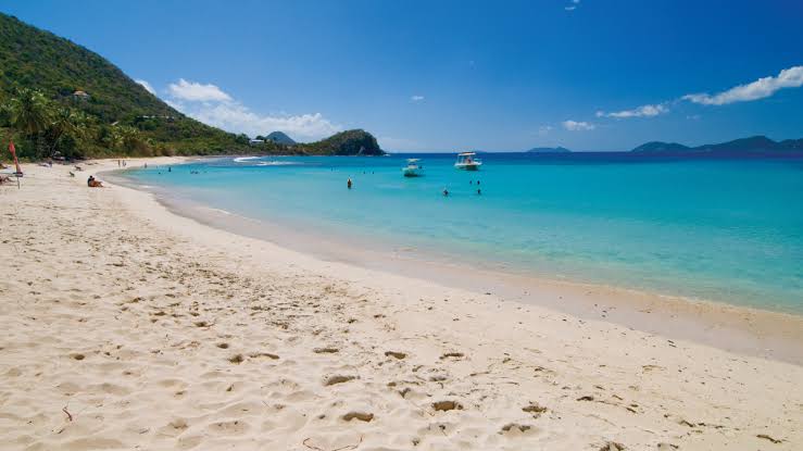 The quiet crescent beach and clear shallows of Smuggler's Cove, Tortola