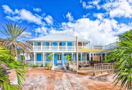Blue-and-white colonial guesthouse with wraparound balconies on Grand Turk